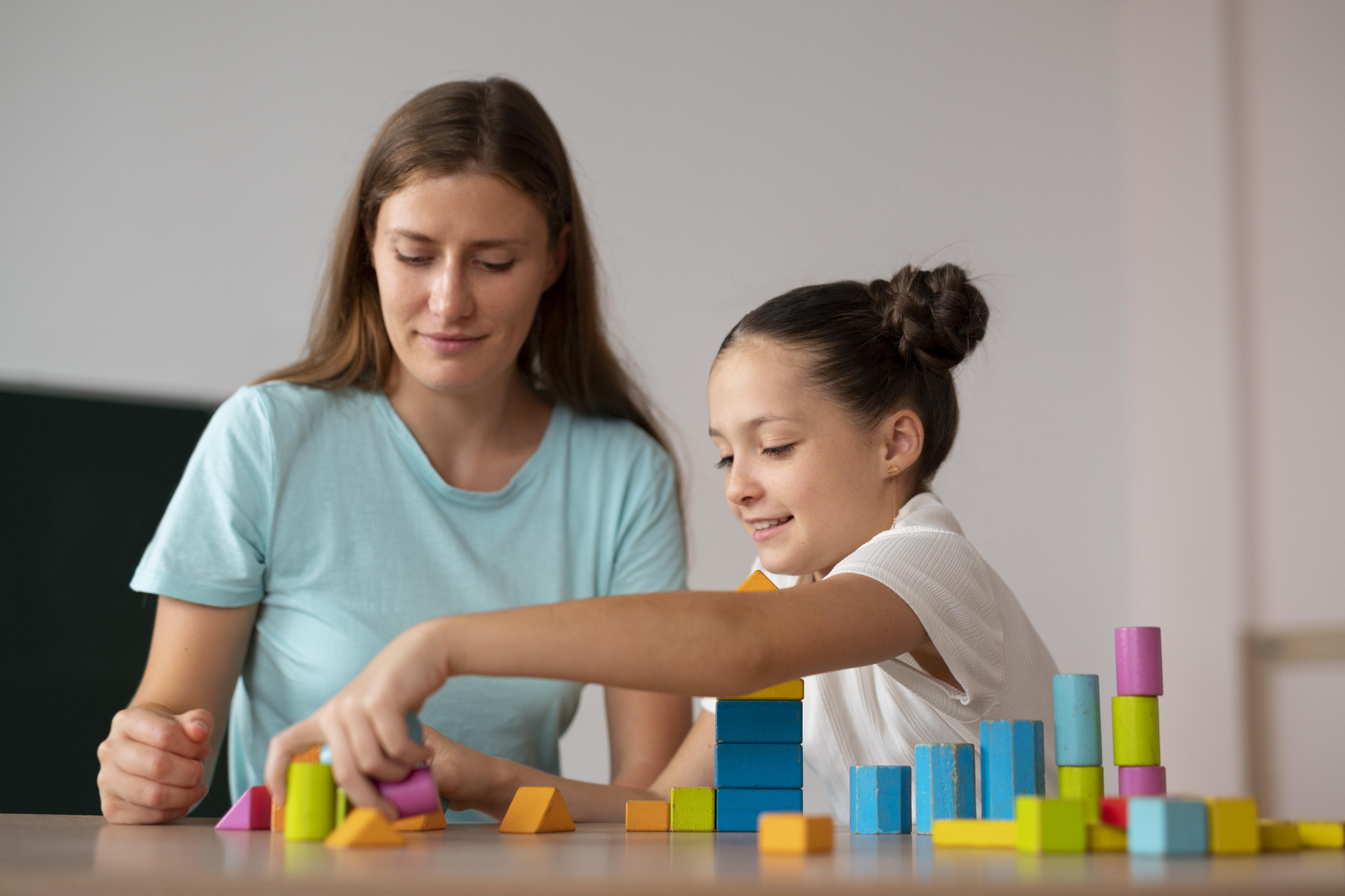 Child stacking colorful blocks during ABA therapy session
